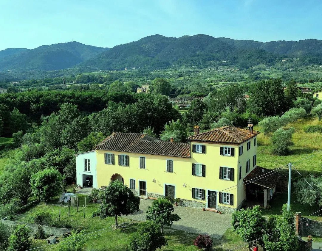 Tuscan farmhouse surrounded by olive groves and rolling hills